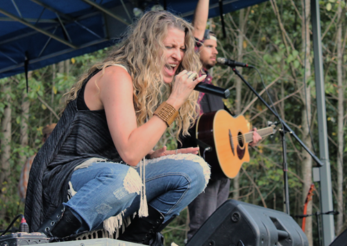 singer belting it out at a concert in the park